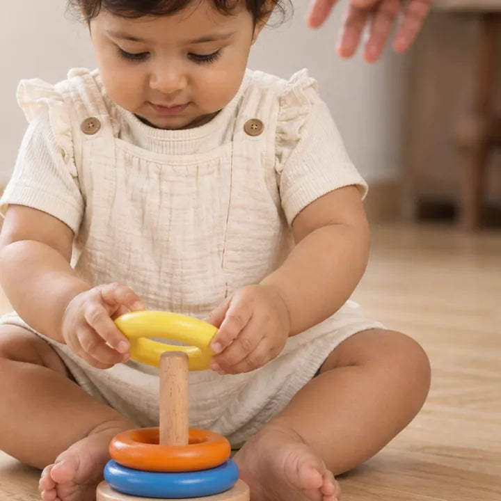 Toddler stacking the wooden ring stacker