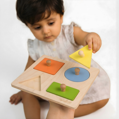 Toddler playing with the BrainyTots Wooden Shape Puzzle by matching colorful wooden shapes for early learning and fine motor development.