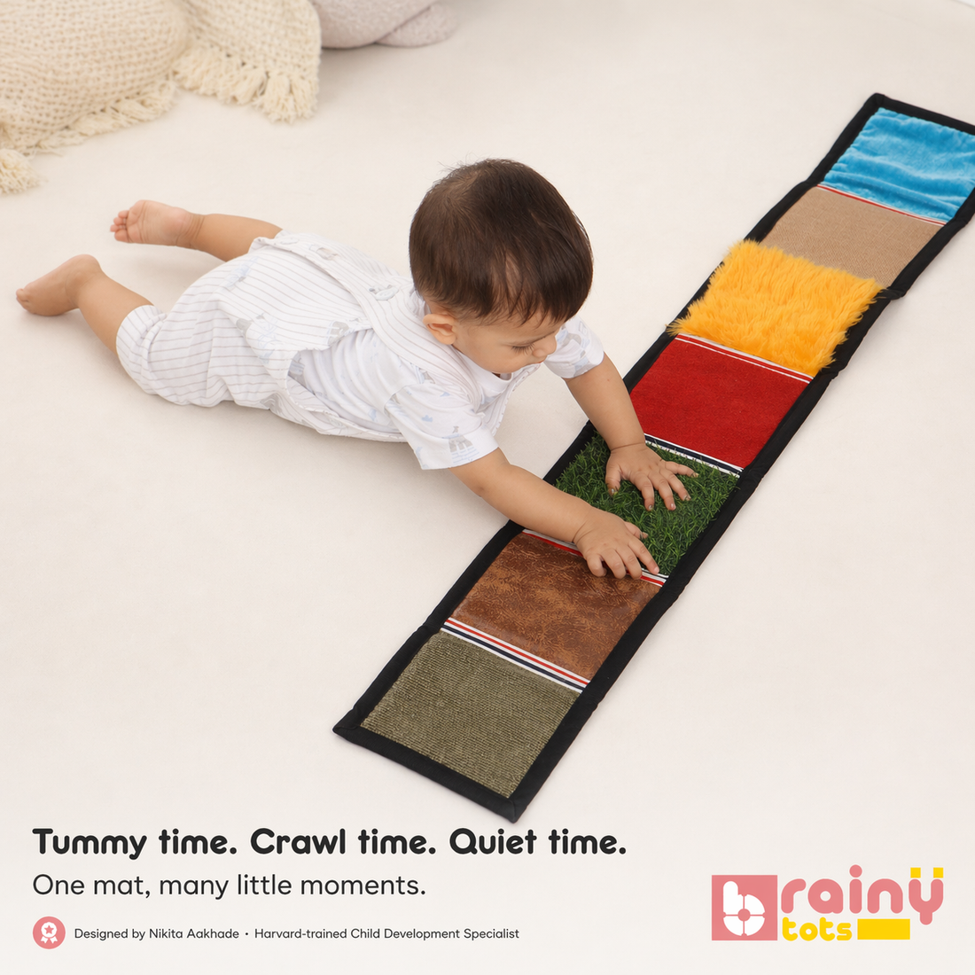 A baby boy during tummy time reaching out to touch a BrainyTots Sensory Texture Mat, designed by a child development specialist to encourage crawling and sensory exploration.