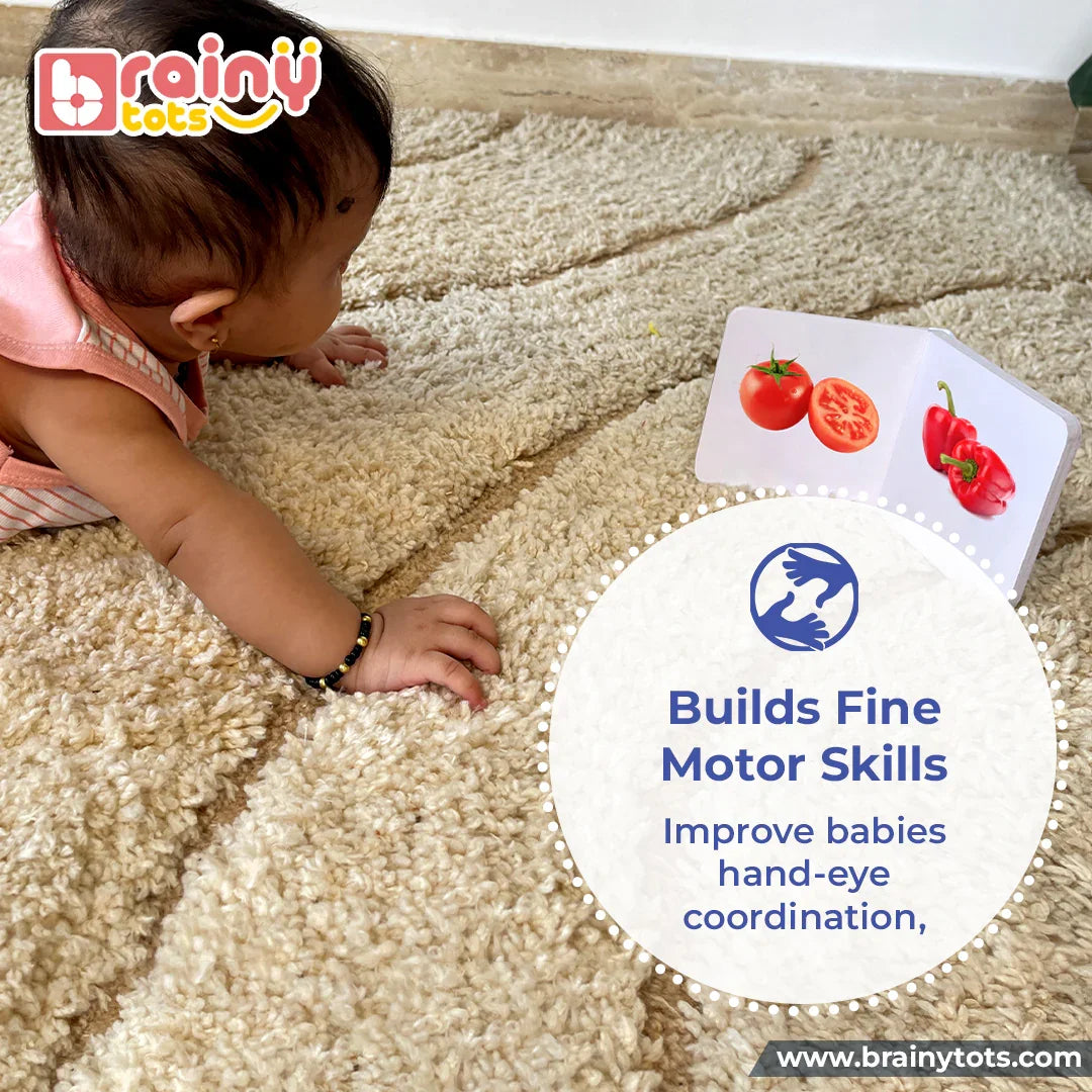 Baby reaching for the BrainyTots Alphabet & Number Board Book featuring colorful vegetable illustrations that build fine motor skills, improve hand-eye coordination, and support early learning for babies aged 3+ months.