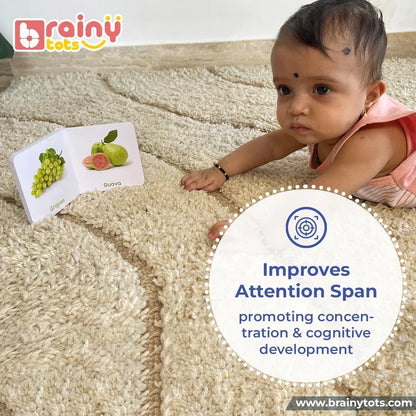 Baby engaged with a colorful fruits board book during tummy time, helping improve attention span, concentration, visual focus, cognitive development, and early learning through interactive picture-based reading.

