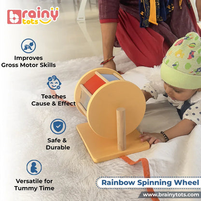 Baby playing with the BrainyTots Rainbow Spinning Wheel during tummy time while reaching to spin the colorful wheel. This Montessori-inspired toy for babies aged 3+ months encourages crawling, strengthens gross motor skills, teaches cause and effect, improves hand-eye coordination, and supports sensory exploration through self-guided play.