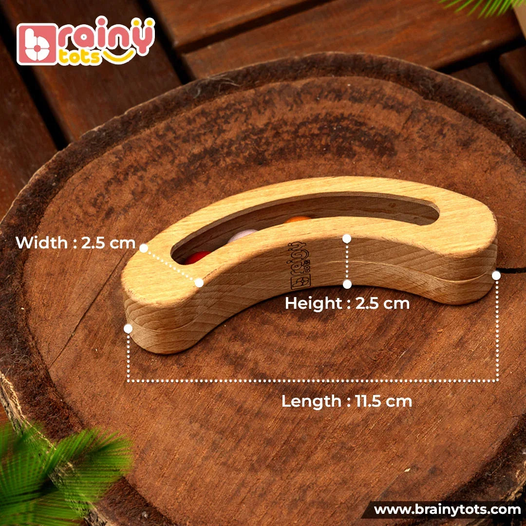 BrainyTots Montessori Banana Busy Beads Rattle dimensions showing 11.5 cm length, 2.5 cm height, and 2.5 cm width, with a curved wooden wobble design and colorful moving beads.