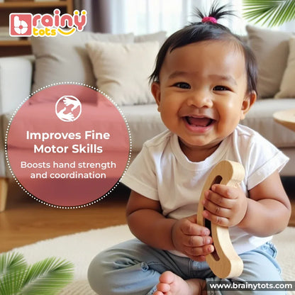 Baby holding the BrainyTots Montessori Banana Busy Beads Rattle to strengthen fine motor skills, hand strength, grasping ability, and hand-eye coordination through interactive wooden sensory play for babies aged 2–18 months.
