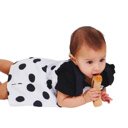 Baby grasping and exploring the BrainyTots Montessori Banana Busy Beads Rattle during tummy time, encouraging tactile exploration, grip practice, and hands-on sensory play.