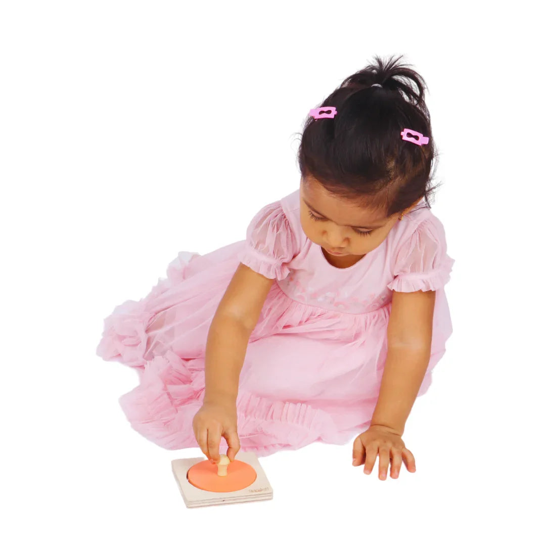 Baby playing with the BrainyTots wooden Circle Shape Puzzle, grasping the ergonomic knob to practice fine motor skills and hand-eye coordination.