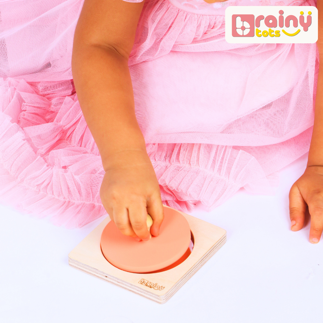 Baby playing with the BrainyTots wooden Circle Shape Puzzle, grasping the removable circular piece to practice fine motor skills and hand-eye coordination.