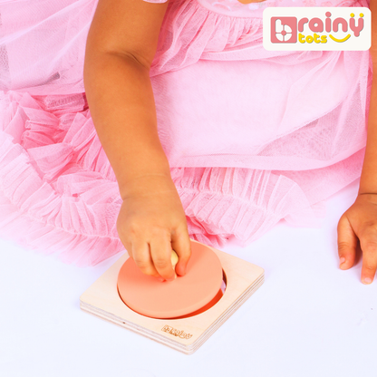 Baby playing with the BrainyTots wooden Circle Shape Puzzle, grasping the removable circular piece to practice fine motor skills and hand-eye coordination.