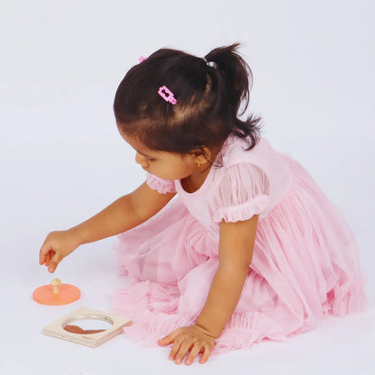 Baby playing with the BrainyTots wooden Circle Shape Puzzle, reaching for the removable piece during hands-on Montessori play.