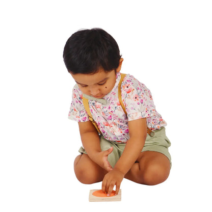 Child playing with the BrainyTots wooden Circle Shape Puzzle, lifting and placing the circular piece during hands-on problem-solving play.