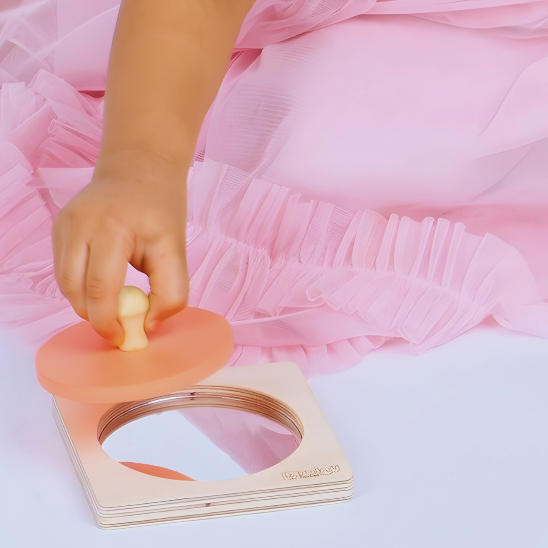 Baby gripping the removable circular piece of the BrainyTots wooden Circle Shape Puzzle, practicing grasping and fine motor skills through hands-on play.