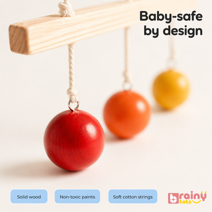 BrainyTots Hang and Hit Height Ball made from solid wood with non-toxic paints and soft cotton strings, providing a baby-safe Montessori toy for sensory exploration, visual tracking, and motor skill development.