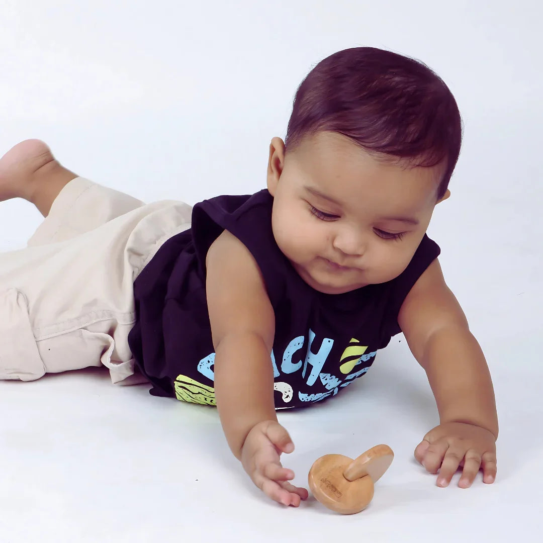 Baby reaching for the BrainyTots Interlocking Discs toy during tummy time and hands-on play.