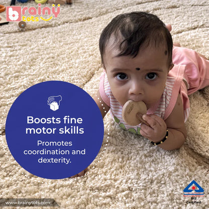 Baby gripping the BrainyTots Interlocking Discs Teether with both hands during fine motor play.