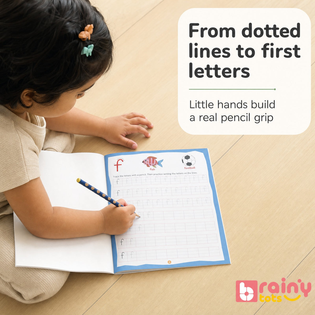 Child tracing dotted letters in a BrainyTots alphabet handwriting workbook using a pencil.