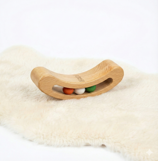 BrainyTots Montessori Banana Busy Beads Rattle made from natural wood, featuring colorful moving beads, a gentle wobble, and soft rattling sounds to encourage fine motor skills, hand-eye coordination, and cause-and-effect learning for babies aged 2–18 months.