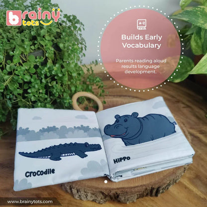 Open BrainyTots Montessori High-Contrast Cloth Book displaying crocodile and hippo illustrations, showing how parent-guided reading helps babies build early vocabulary, language development, visual focus, and cognitive learning from birth.
