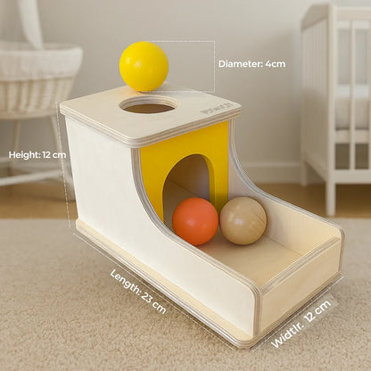 BrainyTots Montessori Object Permanence Box with product dimensions (23 × 12 × 12 cm) and 4 cm wooden balls, designed to develop object permanence, hand-eye coordination, fine motor skills, and early cognitive development through hands-on Montessori play.