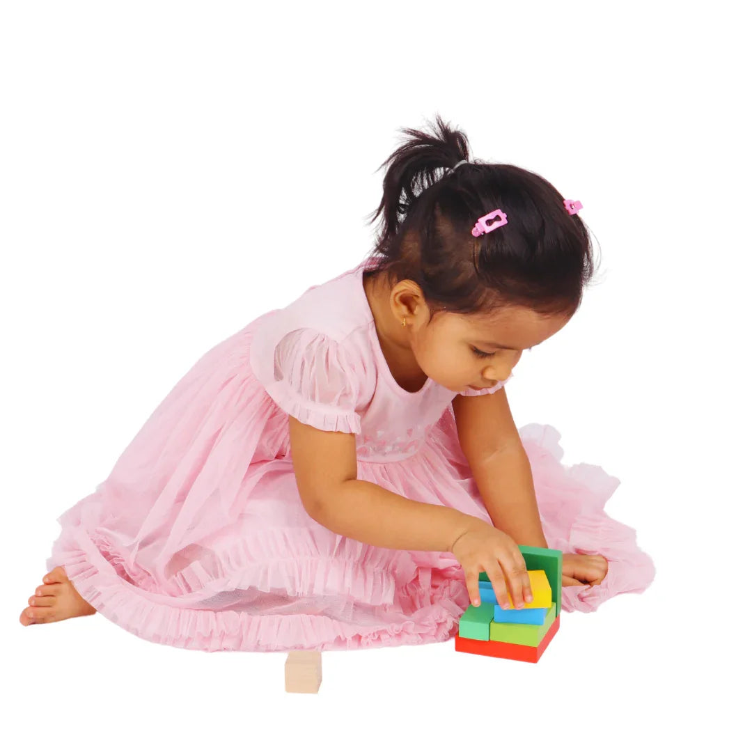 Toddler playing with the BrainyTots Montessori Geometric Rainbow Blocks – Shape & Balance Building Set for children aged 24+ months. Colorful wooden blocks help develop shape recognition, spatial awareness, problem-solving, logical thinking, concentration, and fine motor skills through Montessori learning.