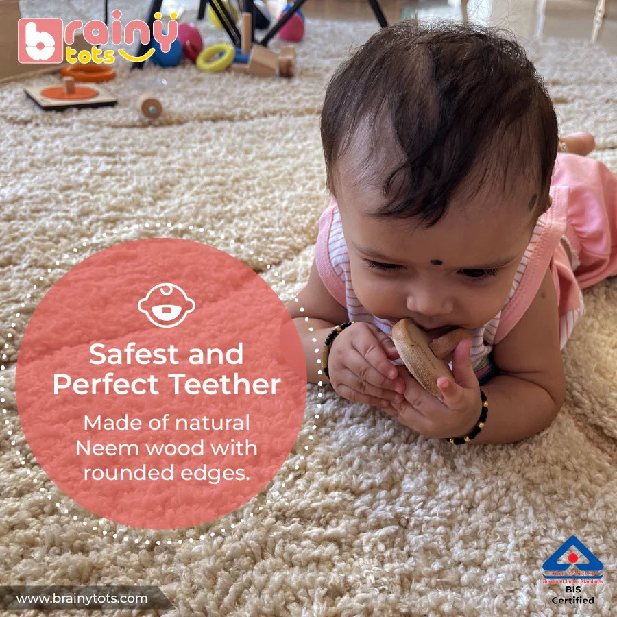Baby chewing the BrainyTots natural Neem wood Interlocking Discs Teether with rounded edges.