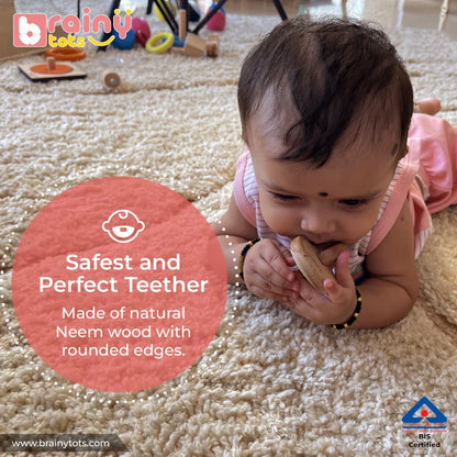 Baby chewing the BrainyTots natural Neem wood Interlocking Discs Teether with rounded edges.