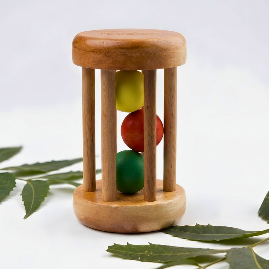 BrainyTots Rolling Drum Rattle made from natural neem wood with colorful rolling balls inside, designed for babies aged 3+ months to encourage grasping, shaking, sensory exploration, crawling, hand-eye coordination, and fine and gross motor development through Montessori-inspired play.