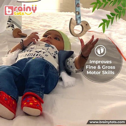 Newborn baby reaching for the BrainyTots Neem Wood Dove Teether from the Montessori Neem Wood Teether Gift Set, encouraging fine and gross motor skills, hand-eye coordination, sensory exploration, and early reaching development.