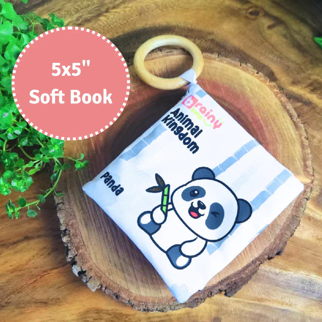 BrainyTots Montessori High-Contrast Cloth Book – Early Seeing & Calm Play Book measuring 5 × 5 inches. This soft jungle-themed sensory book features bold high-contrast illustrations, interactive crinkle pages, and an attached natural Neem wood teether to support visual development, sensory exploration, teething relief, and calm play for babies aged 0–12 months.