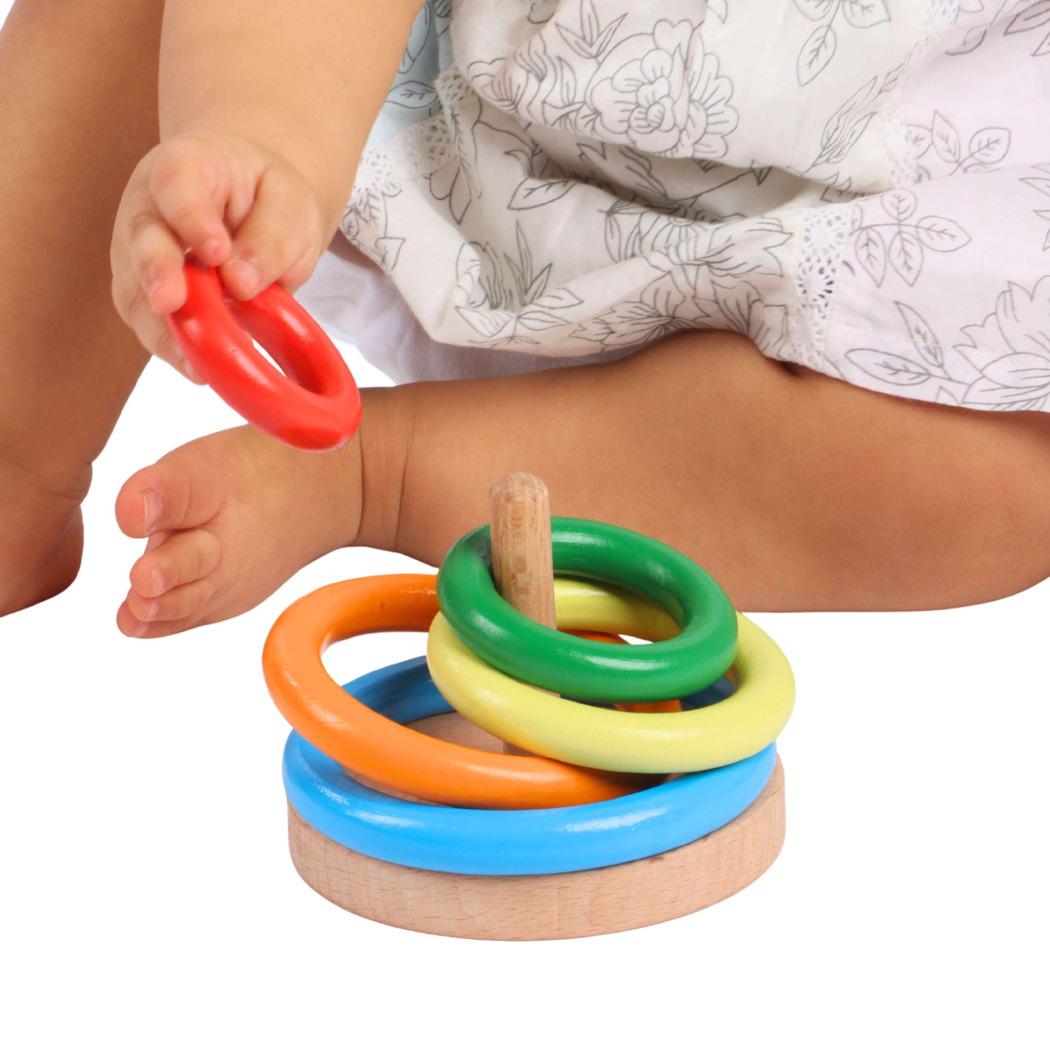Baby stacking colorful rings on the BrainyTots Wooden Ring Stacker, developing fine motor skills, hand-eye coordination, grip strength, color recognition, size sequencing, and problem-solving through Montessori-inspired play with a natural wooden toy for babies aged 6–24 months.