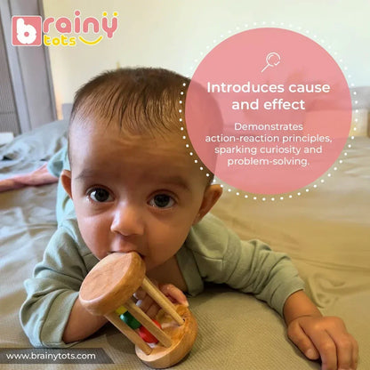 Baby playing with the BrainyTots Montessori Rolling Drum Rattle to explore cause-and-effect learning through rolling, rattling, and interactive sensory play that supports early cognitive development for babies aged 3–12 months.