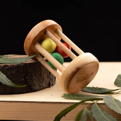 BrainyTots Rolling Drum Rattle made from natural neem wood for babies aged 3+ months, featuring colorful wooden balls that create gentle rattling sounds to encourage grasping, tummy time, crawling, hand-eye coordination, sensory exploration, and gross and fine motor skill development through Montessori-inspired play.