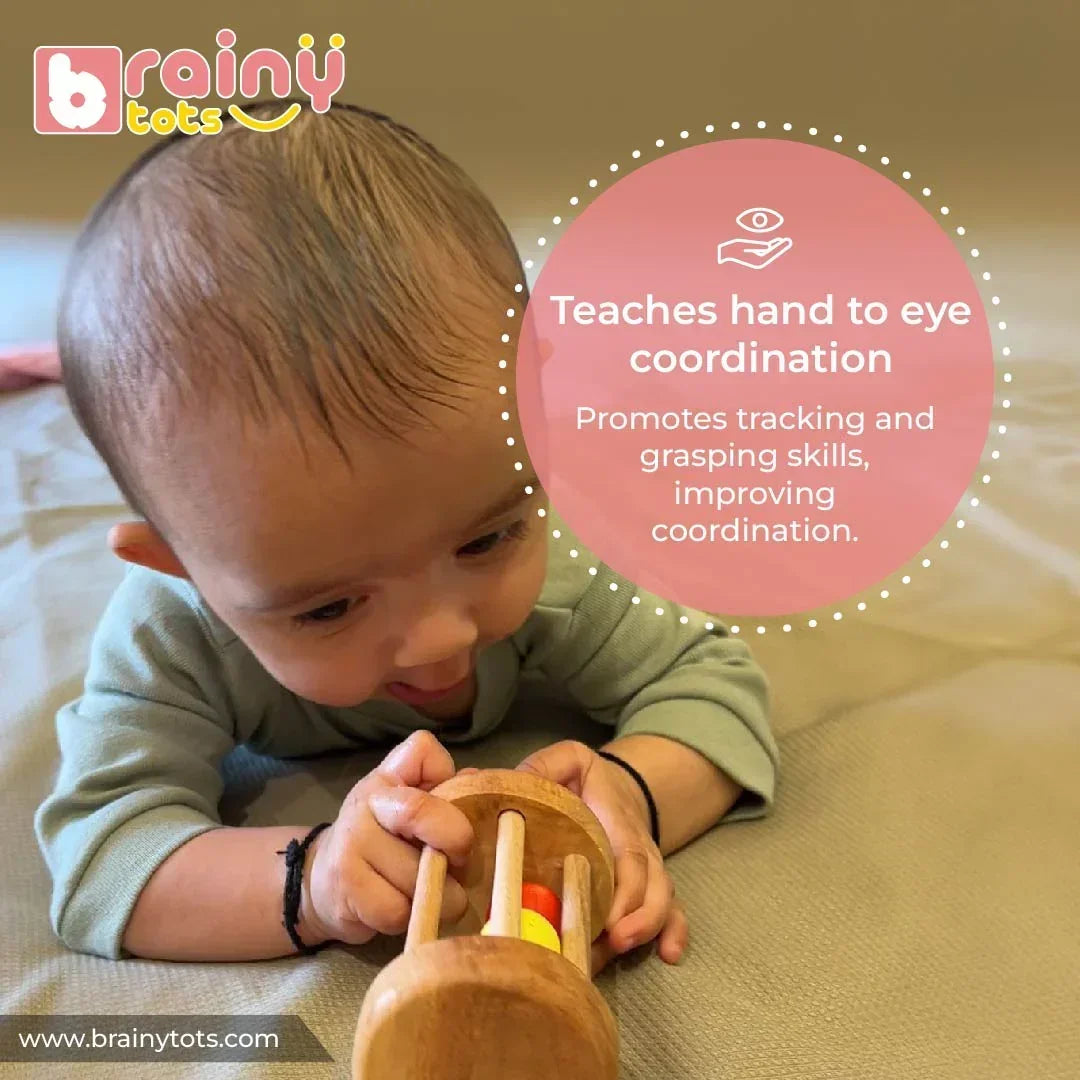 Baby playing with the BrainyTots Montessori Rolling Drum Rattle to improve hand-eye coordination, visual tracking, grasping, and fine motor skills through interactive wooden sensory play for babies aged 3–12 months.