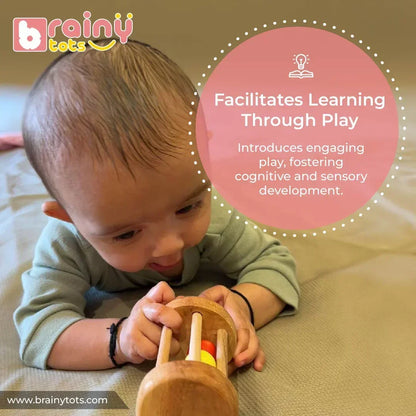 Baby exploring the BrainyTots Montessori Rolling Drum Rattle through interactive play that encourages sensory exploration, cognitive development, problem-solving, and early learning for babies aged 3–12 months.