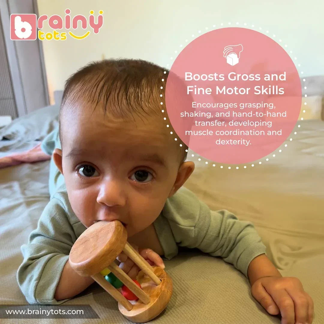 Baby playing with the BrainyTots Montessori Rolling Drum Rattle to develop fine and gross motor skills, hand-eye coordination, grasping, shaking, and hand-to-hand transfer for babies aged 3–12 months.