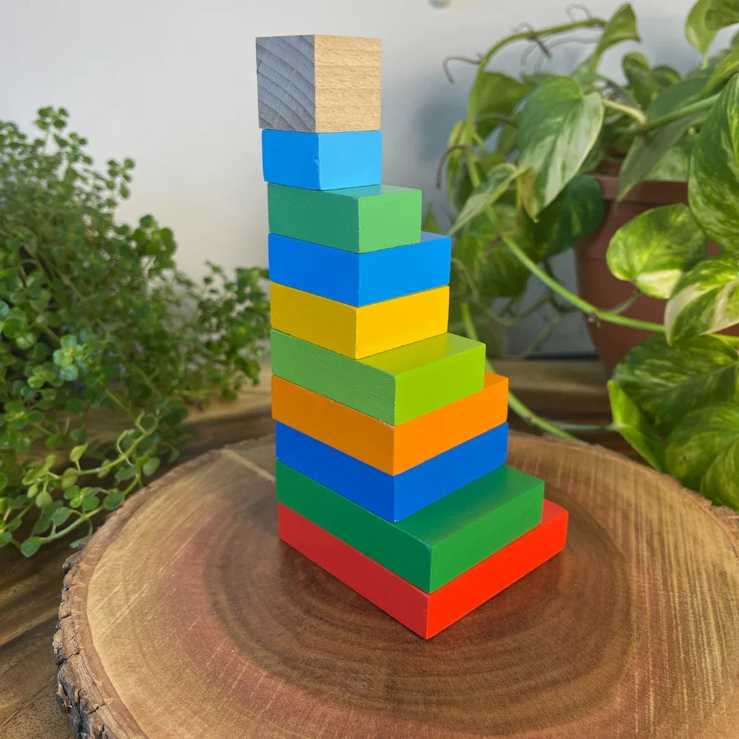 Toddler tower built using the BrainyTots Montessori Geometric Rainbow Blocks – Shape & Balance Building Set. This colorful wooden block set encourages creative building, balance, spatial awareness, problem-solving, logical thinking, hand-eye coordination, and fine motor skill development through open-ended Montessori play for children aged 24+ months.