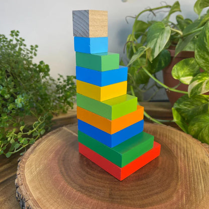 Toddler tower built using the BrainyTots Montessori Geometric Rainbow Blocks – Shape & Balance Building Set. This colorful wooden block set encourages creative building, balance, spatial awareness, problem-solving, logical thinking, hand-eye coordination, and fine motor skill development through open-ended Montessori play for children aged 24+ months.