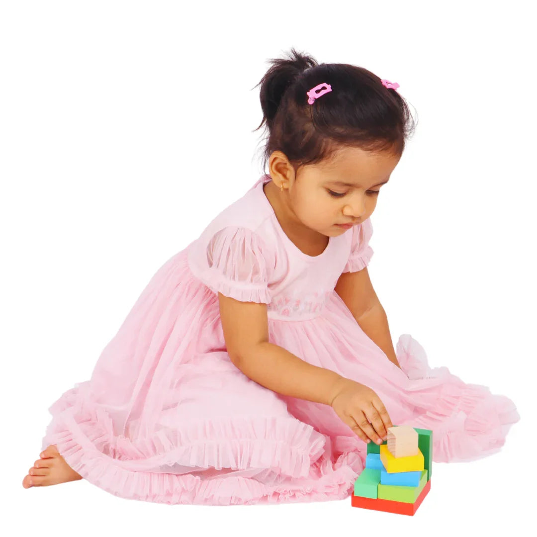 Toddler arranging the BrainyTots Montessori Geometric Rainbow Blocks – Shape & Balance Building Set to complete the colorful cube. Designed for children aged 24+ months, this Montessori-inspired wooden toy develops shape recognition, spatial awareness, logical thinking, problem-solving, concentration, hand-eye coordination, and fine motor skills through hands-on play.