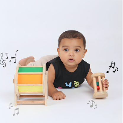 Baby enjoying the BrainyTots Baby Crawling Combo featuring the Rainbow Spinning Wheel and Neem Wood Rolling Drum Rattle. This Montessori-inspired tummy time toy set for babies aged 3+ months encourages crawling, strengthens core muscles, improves hand-eye coordination, stimulates hearing with gentle rattling sounds, and supports gross and fine motor development through sensory play.