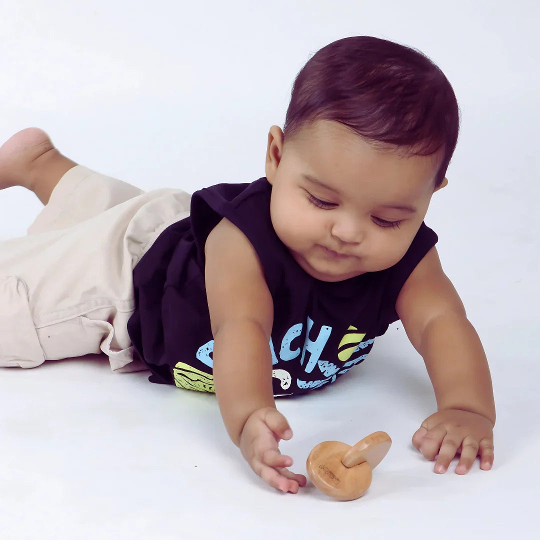 Baby exploring the BrainyTots wooden Interlocking Discs toy while reaching and grasping during play.