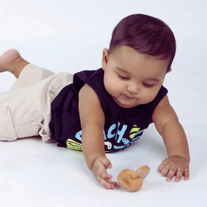 Baby exploring the BrainyTots wooden Interlocking Discs toy while reaching and grasping during play.
