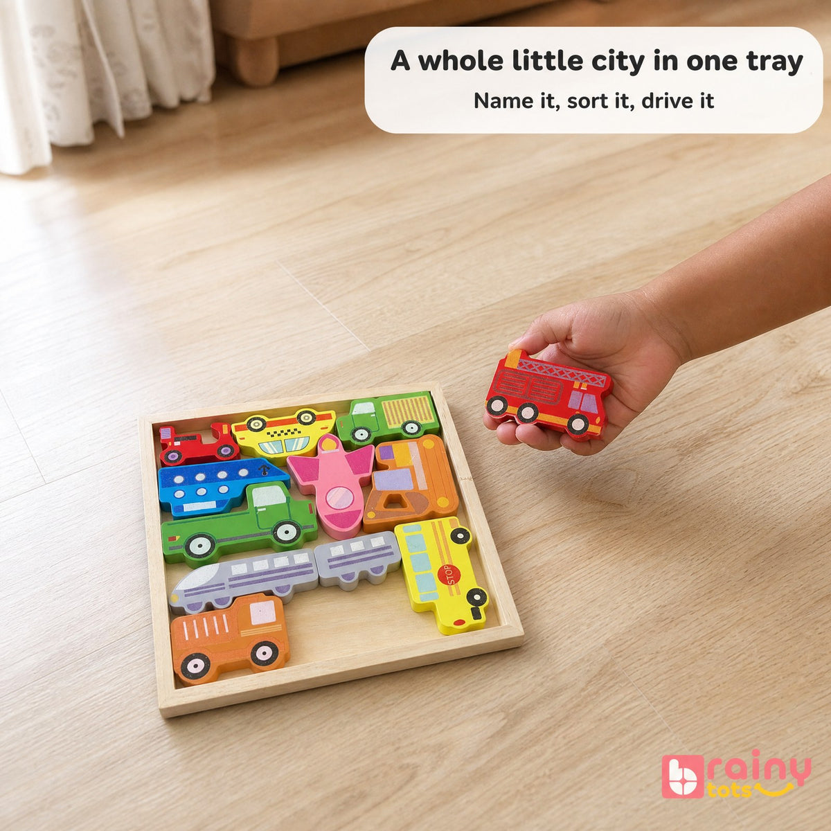Toddler holding a wooden fire engine from the BrainyTots vehicle puzzle while exploring and naming different vehicles.