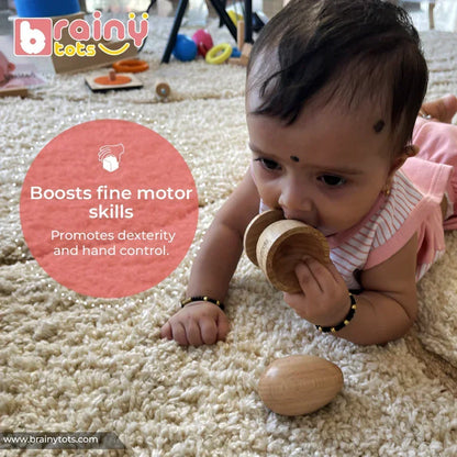 Baby on tummy exploring a natural wooden Montessori egg and cup puzzle by mouth, holding the smooth cup piece while the egg rests nearby on a soft rug, promoting fine motor skills and sensory discovery for infants 6–15 months.
