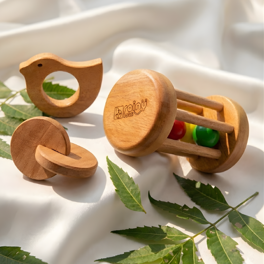 Neem Wood Teether Gift Set for Newborn featuring a Rolling Drum Rattle, Interlocking Discs Teether, and Dove Neem Teether made from natural antibacterial Neem wood to encourage sensory exploration, teething relief, fine motor skills, hand-eye coordination, and early cognitive development for babies aged 1 month and above.