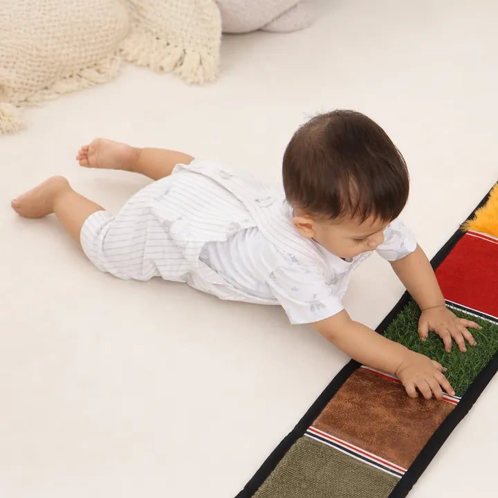 Baby on tummy time, touching the sensory texture mat